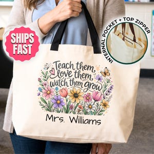 May include: Cream-colored tote bag with black handles. The bag features a floral design with the text "Teach them, love them, watch them grow" and "Mrs. Williams". Includes an internal pocket and top zipper.