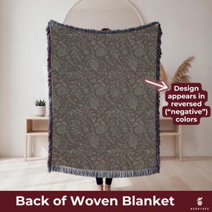 May include: A woven blanket with a floral pattern in shades of brown and green. The blanket has a fringed edge and the text "Back of Woven Blanket". The design appears in reversed colors.