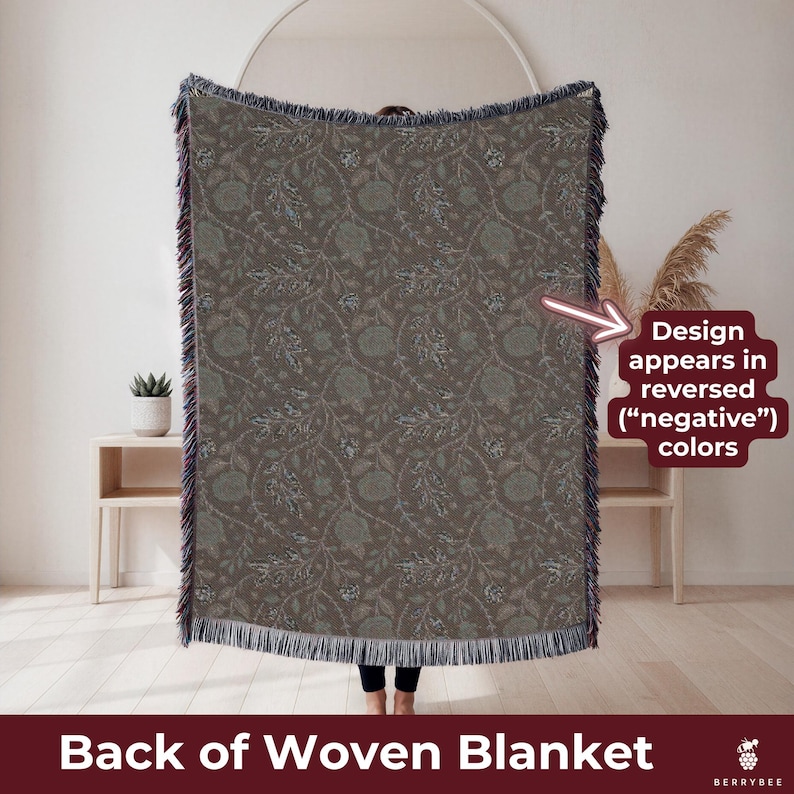 May include: A woven blanket with a floral pattern in shades of brown and green. The blanket has a fringed edge and the text "Back of Woven Blanket". The design appears in reversed colors.