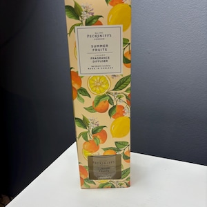 May include: A rectangular box for a Pecksniff's London Summer Fruits luxury fragrance diffuser. The packaging features a cream background with illustrations of yellow lemons, orange citrus fruits, green leaves, and white blossoms. Net 100 ml / 3.3 US fl oz.
