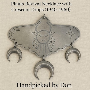 May include: A silver-toned Plains Revival necklace with crescent drops. The pendant features a cloud-like shape with a bull design, a star, and a crescent moon. The necklace is from the 1940-1960s era. The text "Handpicked by Don" is also visible.
