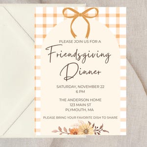 Op de afbeelding: Een uitnodiging voor een Friendsgiving-diner. Het ontwerp heeft een crèmekleurige achtergrond met een oranje en wit geruit patroon. De tekst bevat de evenementdetails. Links staat een crèmekleurige envelop.