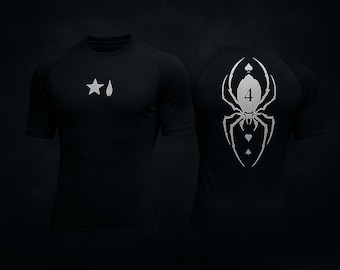 Puede incluir: Camiseta deportiva negra de manga corta con gráficos blancos. La parte delantera presenta un diseño de estrella y gota. La parte trasera muestra un gráfico de araña con el número 4 y símbolos de palo de cartas. La camiseta es de material elástico.