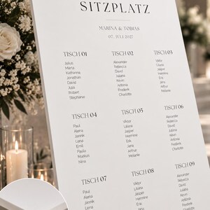 May include: A white wedding seating chart sign with black text reading "finde deinen SITZPLATZ", "MARINA & TOBIAS", and "07. JULI 2027", listing guest names under nine tables. A circular inset shows the 5 mm thick foam board material.