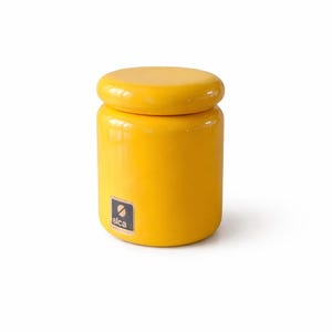 May include: A white ceramic mug with a black handle and the text "But First, Coffee" in a handwritten style. The mug is on a white surface. The mug is approximately 10 cm tall.