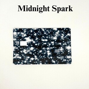 Pu&ograve; includere: Una carta rettangolare con sfondo nero punteggiato da disegni bianchi a forma di stella e rotondi. Il testo "Midnight Spark" &egrave; stampato in nero nella parte superiore della carta.