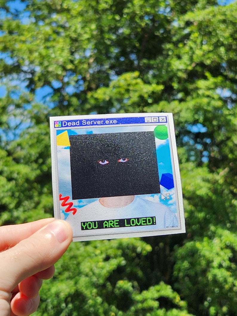 May include: A square sticker with a retro computer-style design. The sticker features the text "Dead Server.exe" at the top and "YOU ARE LOVED!" at the bottom. The center of the sticker has a black box with two eyes.