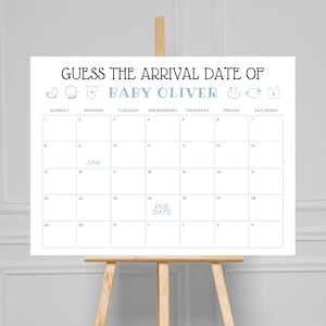 Puede incluir: Un letrero blanco sobre un caballete con el texto "GUESS THE ARRIVAL DATE OF BABY OLIVER." Debajo hay una cuadrícula de calendario, con el mes de junio resaltado. Las palabras "DUE DATE" están escritas el 25.