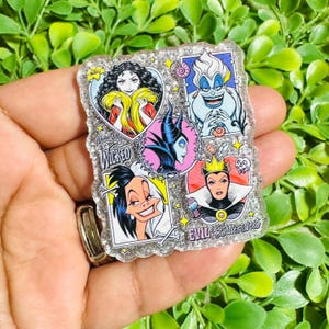May include: A rectangular glittery acrylic pin featuring four illustrated female villains in separate frames. The text "Wonderfully WICKED" and "EVIL & Bittersweet" is printed on the surface. The characters include Mother Gothel, Ursula, Maleficent, and the Evil Queen.