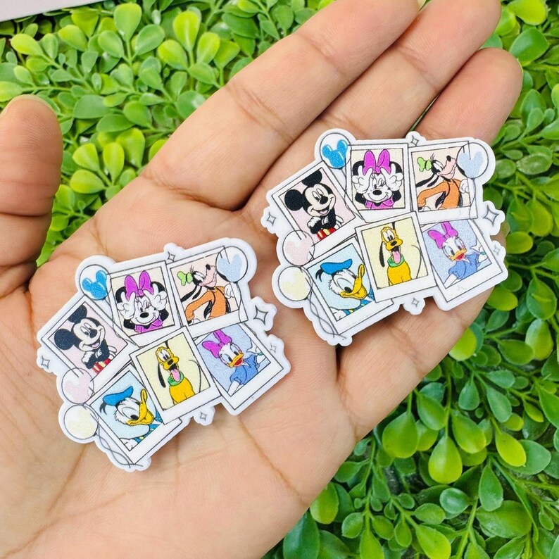 K&ouml;nnte beinhalten: Zwei Sets von Aufklebern mit Disney-Charakteren. Jedes Set zeigt sechs Charaktere in einem Polaroid-Design, darunter Micky Maus, Minnie Maus, Goofy, Donald Duck, Daisy Duck und Pluto. Die Aufkleber haben einen wei&szlig;en Rand und Pastellakzente.