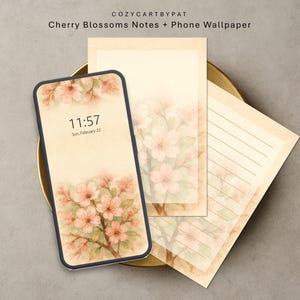 Puede incluir: Un smartphone con un fondo de pantalla de flores de cerezo, acompañado de dos blocs de notas con diseños florales a juego. El teléfono muestra la hora 11:57 el 22 de febrero. Los blocs de notas presentan páginas rayadas y en blanco, todo con una estética vintage suave.