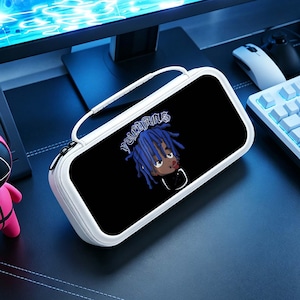 May include: White and black carrying case with a handle. The case features a black graphic of a cartoon character with blue hair and the word "VULGARIS" in white. The case is on a black surface.