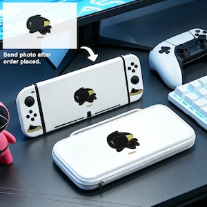 Op de afbeelding: Witte Nintendo Switch console en draagtas met een zwart en geel grafisch ontwerp. De afbeelding toont ook een witte controller, een toetsenbord en de tekst "Send photo after order placed."