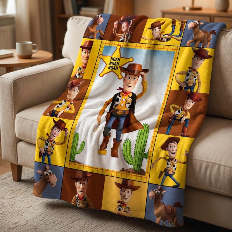 Op de afbeelding: Een zachte deken met een ontwerp van Woody uit Toy Story. De centrale afbeelding toont Woody met een cactus, omringd door andere afbeeldingen van Woody en een paard. De deken ligt op een beige bank.