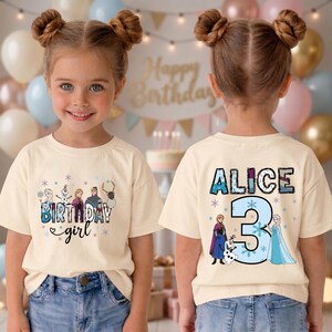 May include: A cream-colored t-shirt featuring a birthday theme. The front displays the text "Birthday Girl" with cartoon characters. The back of the shirt has the name "Alice" and the number "3" with cartoon characters.