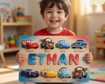 Op de afbeelding: Een rechthoekig houten puzzelbord met de naam ETHAN in grote, kleurrijke, verhoogde letters. Het bord toont acht cartoon-autopersonages uit de film Cars, waaronder McQueen, Mater, Sally, Doc Hudson, Storm, Cruz, Luigi en Ramone.