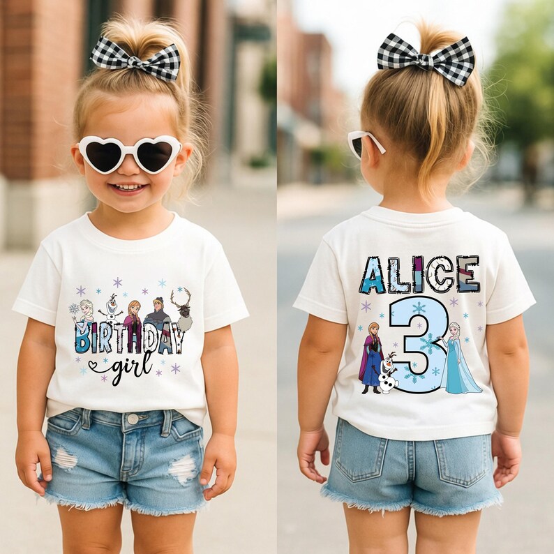 May include: A white t-shirt with a colorful "Birthday girl" graphic and cartoon characters. The back of the shirt features the name "Alice" and the number "3" with cartoon characters. The girl is wearing denim shorts and heart-shaped sunglasses.