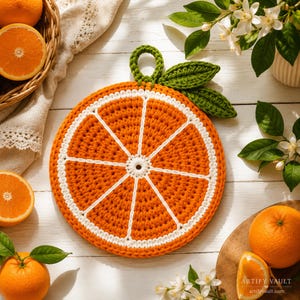 May include: A round, crocheted orange slice pot holder featuring vibrant orange yarn segments separated by white yarn lines. It includes a green crocheted leaf and a small hanging loop at the top, crafted with a textured, thick yarn stitch pattern.
