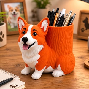 May include: A bright orange and white Corgi-shaped desk organizer featuring a cylindrical compartment for pens and pencils. The dog figure has a detailed face with a black nose, open mouth with a pink tongue, and upright ears, with a textured body.