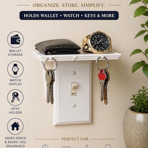 Könnte beinhalten: Weißer Lichtschalter mit einem Regal, das eine schwarze Brieftasche und eine goldene Uhr hält. Die Abdeckung hat Schlüsselhaken und den Text "SWITCH COVER" und "HOLDS WALLET • WATCH • KEYS & MORE". Es dient zum Organisieren und Vereinfachen.