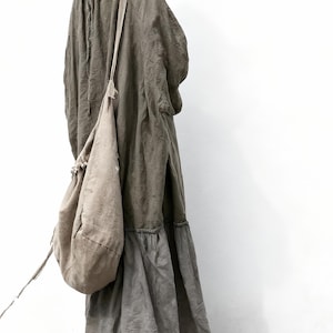 Puede incluir: Vestido largo verde oliva con cuello con cord&oacute;n y falda escalonada. Se lleva un bolso de hombro a juego. El vestido est&aacute; hecho de una tela suave y fluida, de estilo casual y bohemio.