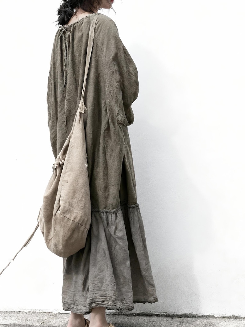 Puede incluir: Vestido largo verde oliva con cuello con cord&oacute;n y falda escalonada. Se lleva un bolso de hombro a juego. El vestido est&aacute; hecho de una tela suave y fluida, de estilo casual y bohemio.