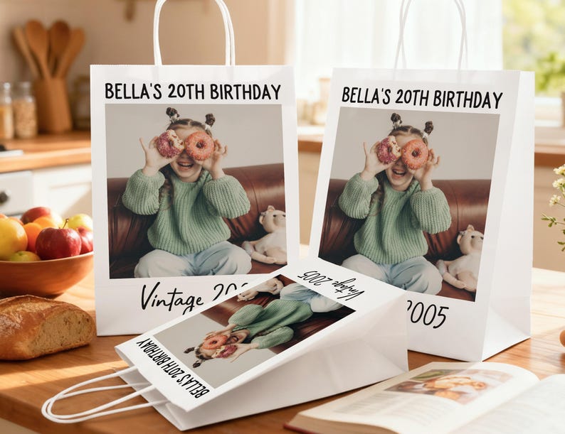 Pu&ograve; includere: Sacchetti regalo di carta bianca con manici, con una foto di una ragazza che tiene delle ciambelle davanti agli occhi. Il testo "BELLA'S 20TH BIRTHAY" e "Vintage 2005" sono stampati sui sacchetti. &Egrave; visibile anche un sacchetto pi&ugrave; piccolo con lo stesso design.