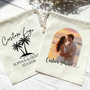 Könnte beinhalten: Zwei cremefarbene Kordelzugbeutel. Einer zeigt ein individuelles Logo mit Palmen und Text. Der andere Beutel hat ein individuelles Foto eines Paares vor einem Sonnenuntergang. Beide Beutel haben einen cremefarbenen Kordelzug.