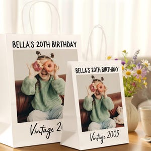 Pu&ograve; includere: Sacchetti regalo bianchi con manici, con una foto di una ragazza che tiene delle ciambelle sugli occhi. Il testo "BELLA'S 20TH BIRTHDAY" e "Vintage 2005" sono stampati sui sacchetti. Un mazzo di fiori e una tazza di caff&egrave; sono sullo sfondo.