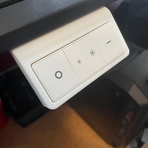 May include: A white smart light switch with three buttons. The buttons have symbols for power, brightness, and dimming. The switch is mounted on a dark surface.