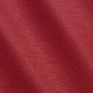 May include: A deep red material with a distinct, pebbled, and textured surface. The material displays a consistent grain pattern across the entire view, characterised by small, irregular bumps and indentations that create a matte finish.