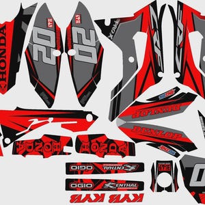 Può includere: Un set di adesivi per moto in rosso, nero e grigio con marchio Honda, il numero 20 e vari loghi di sponsor tra cui Dunlop, Ogio, Renthal e Wiseco, progettati per l'applicazione sui pannelli della carrozzeria e sui parafanghi delle moto.