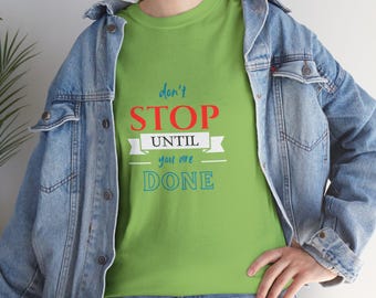 May include: A lime green t-shirt with the text "don't STOP UNTIL you are DONE" in red, white, and blue. The shirt is worn with a blue denim jacket and jeans.