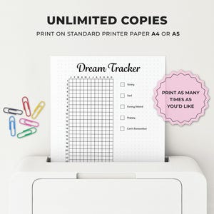 May include: A white printer with a printed "Dream Tracker" sheet. The sheet has a grid for tracking dreams, with checkboxes for emotions. Text reads "Unlimited Copies" and "Print as many times as you'd like". Colorful paperclips are scattered nearby.