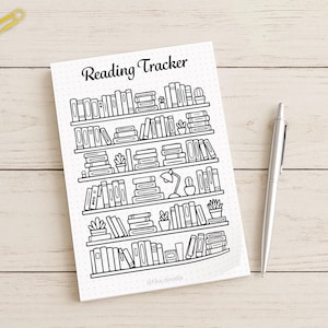 Flat lay photo of a printed reading tracker bookshelf page with pen for bullet journal use