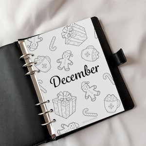 December monthly cover page from a 2026 printable planner shown inside a ring binder, featuring a festive black and white design, planner and bullet journal printable cover page displayed in a realistic planner mockup, instant digital download