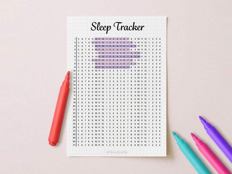 May include: A white "Sleep Tracker" printable with a grid for tracking sleep patterns. The grid is filled with numbers and highlighted sections. A red marker and three other colored markers are on the light pink surface.