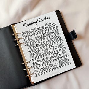 Reading tracker printable inserted in a planner binder showing bookshelf design for tracking books read
