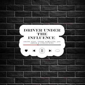 Puede incluir: Una pegatina blanca con el texto "DRIVER UNDER THE INFLUENCE" en negro, con los nombres SHANE EAST, TEDDY HAMILTON, JOE ARDEN & CORVIN KING. La pegatina tiene un diseño de interfaz de reproductor de música con iconos de reproducción, pausa y otros controles. El fondo es una pared de ladrillos negra.