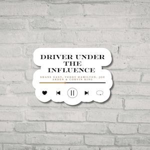 May include: White sticker with the text "DRIVER UNDER THE INFLUENCE" in a music player design. Below the title are the names Shane East, Teddy Hamilton, Joe Arden & Corvin King. The sticker has a heart, rewind, pause, fast forward, and a cloud icon.