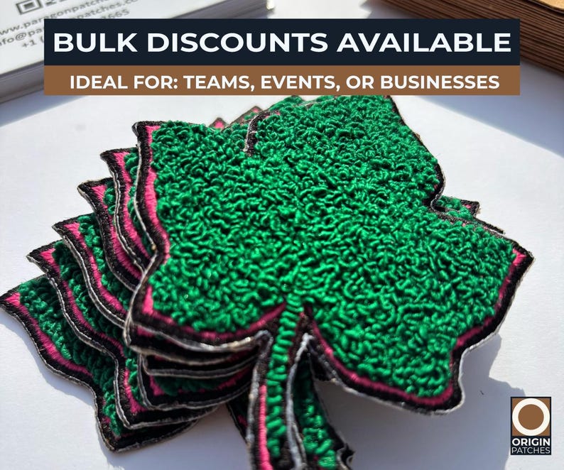 May include: A stack of green shamrock patches with pink and black trim. The patches have a textured appearance and are likely embroidered. The text "BULK DISCOUNTS AVAILABLE" is visible at the top of the image.