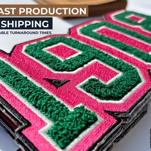 May include: Close-up of stacked embroidered patches with the number "1990" in green and white on a pink background. The patches have a textured, fuzzy appearance. The text "FAST PRODUCTION & SHIPPING" is at the top.