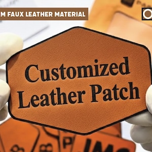 Pode incluir: Um patch hexagonal castanho em couro sintético com as palavras "Customized Leather Patch" em preto. O patch é segurado por mãos enluvadas. O texto "PREMIUM FAUX LEATHER MATERIAL" está no topo. O logotipo Origin Patches está no canto superior direito.