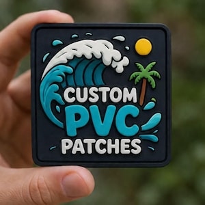 Pode incluir: Um emblema quadrado de PVC preto com um gráfico em relevo de uma onda azul com espuma branca, um sol amarelo e uma palmeira verde. O texto CUSTOM PVC PATCHES está gravado em letras brancas e azuis no centro do design.