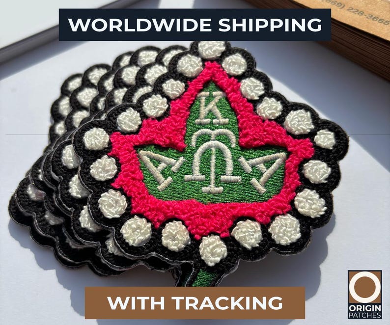 May include: A stack of embroidered patches with a green, red, black, and white design. The patches feature a central emblem with Greek letters and a leaf shape. The text "WORLDWIDE SHIPPING" is at the top.