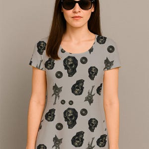 May include: A light gray dress featuring a repeating pattern of geometric skulls, guitars, and vinyl records. The dress has short sleeves and a scoop neckline. The text "Miss Pattern" is visible at the top left.