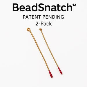 May include: Two gold-colored BeadSnatch™ bead stringing needles with red tips. The needles are thin and have a loop at one end. The text "BeadSnatch™", "PATENT PENDING", and "2-Pack" are visible.
