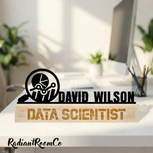 May include: A wooden desk nameplate featuring the name "DAVID WILSON" in black, above the words "DATA SCIENTIST" in a lighter wood tone. A black graphic of a magnifying glass with a pie chart and bar graph is on the left.