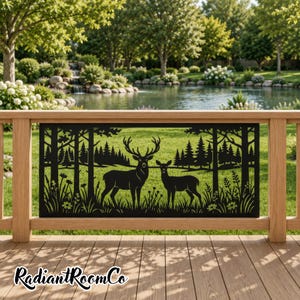 May include: A rectangular black metal privacy screen featuring a laser-cut silhouette of a stag and a doe standing in a forest clearing with tall trees and wildflowers. The panel is mounted horizontally between two wooden posts on a deck.