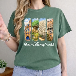 Puede incluir: Camiseta verde con un gr&aacute;fico colorido que muestra los lugares emblem&aacute;ticos de Walt Disney World. El dise&ntilde;o incluye el castillo de Cenicienta, el &Aacute;rbol de la Vida, Spaceship Earth y el Hollywood Tower Hotel. Las palabras "Walt Disney World" est&aacute;n impresas en blanco debajo.